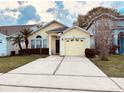 Inviting one-story house features a driveway, nice lawn, and bright yellow exterior paint at 3361 Hamlet Loop, Winter Park, FL 32792