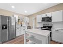 Bright kitchen with white cabinets, stainless steel appliances and an island at 3518 Shirley Dr, Apopka, FL 32703