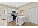 Bright kitchen features white cabinetry, stainless steel appliances, and a functional island at 3518 Shirley Dr, Apopka, FL 32703
