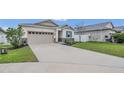 Beautiful single-Gathering home showcasing a driveway and tasteful landscaping at 4009 Swan Goose Ct, Okahumpka, FL 34762