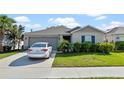 Well maintained home with neat landscaping and an attached two-car garage with a car in the driveway at 4475 Casablanca Ave, Kissimmee, FL 34746