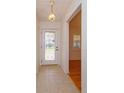 Foyer with tile flooring, decorative glass front door and view to dining room at 519 Cornwall Rd, Winter Park, FL 32792