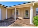 Covered front porch with brick flooring and white columns offering a welcoming entrance at 519 Cornwall Rd, Winter Park, FL 32792
