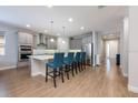 Modern kitchen with stainless steel appliances, a large island, and stylish blue chairs at 706 Hyperion Dr, Debary, FL 32713