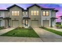 Charming townhomes featuring attached garages, modern architecture, and landscaped front yards at 730 Longboat Dr, Davenport, FL 33896