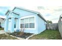 Attractive one-story home with a light blue exterior, framed by green lawn and clean landscaping at 743 Belvoir Dr, Davenport, FL 33837