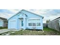 Inviting one-story home with a light blue exterior and a well-kept front yard and single car garage at 743 Belvoir Dr, Davenport, FL 33837