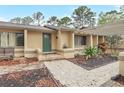 Inviting home entrance with lush landscaping, a beautiful stone walkway, pergola, and cozy bench seating at 811 Gatehouse Dr, Winter Springs, FL 32708