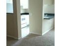 Small kitchen with black countertops and white appliances, adjacent to a carpeted living space at 860 N Orange Ave # 444, Orlando, FL 32801