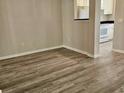 Open-concept living area featuring modern wood-look flooring and convenient kitchen access at 860 N Orange Ave # 444, Orlando, FL 32801