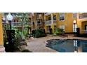 Nighttime view of a community pool surrounded by lush landscaping and building balconies at 860 N Orange Ave # 444, Orlando, FL 32801