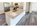 The renovated kitchen offers stainless steel appliances, a granite countertop island and updated white cabinets at 1 Pine Radial Trl, Ocala, FL 34472