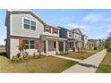 Street with houses with red shutters, landscaping, and a sidewalk create a welcoming neighborhood at 11356 Sunsail Ave, Orlando, FL 32832