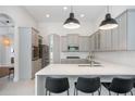 Bright and airy kitchen with gray cabinets, quartz countertops, stainless appliances, and breakfast bar seating at 11537 Claymont Cir, Windermere, FL 34786