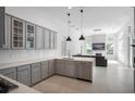 Modern kitchen featuring stainless steel appliances, gray cabinets, quartz countertops, and pendant lighting at 11537 Claymont Cir, Windermere, FL 34786