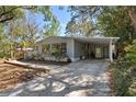 Inviting single-story home with covered carport and driveway, surrounded by mature trees at 144 E Plantation Blvd, Lake Mary, FL 32746