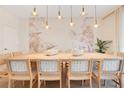 Elegant dining room with seating for twelve, modern lighting, and a floral accent wall at 1445 Rolling Fairway Dr, Davenport, FL 33896