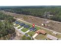 Aerial view of a single-story home nestled amongst trees with a gravel road nearby at 17046 Sw 44Th Cir, Ocala, FL 34473