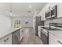 Modern kitchen with white cabinets, stainless steel appliances, and hardwood flooring at 17046 Sw 44Th Cir, Ocala, FL 34473
