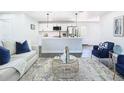 Bright living room with modern decor, an open kitchen, stainless steel appliances, and hardwood floors at 2411 Crawford Dr, Sanford, FL 32771