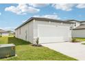 Charming exterior of the house featuring a two-car garage and a well-maintained lawn and landscaping at 2511 Linda Knoll Ln, Bartow, FL 33830
