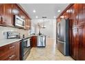 Modern kitchen with stainless steel appliances, granite countertops, and dark wood cabinets at 2524 Monaco Cove Cir, Orlando, FL 32825