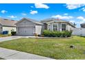 Charming single-story home featuring a two-car garage, manicured lawn, and lovely curb appeal at 3086 Brenton Manor Loop, Winter Haven, FL 33881