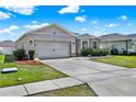 Well-maintained home features a gray exterior, two-car garage, and a wide driveway at 3086 Brenton Manor Loop, Winter Haven, FL 33881