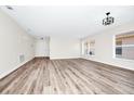 Expansive living room featuring continuous wood flooring, neutral paint, modern lighting, and multiple windows at 3156 Natoma Way, Orlando, FL 32825