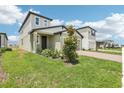 Inviting two-story home with a well-kept lawn, brick driveway, and a welcoming front entrance at 3213 Viceroy Ct, Poinciana, FL 34759
