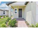 Charming front porch with brick walkway, lush landscaping, and an inviting entrance at 3213 Viceroy Ct, Poinciana, FL 34759