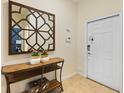 Inviting entryway with a console table, decorative mirror, and white front door at 4895 Clock Tower Dr, Kissimmee, FL 34746