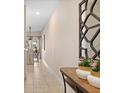 Welcoming hallway with neutral walls, tile flooring, and a decorative mirror at 4895 Clock Tower Dr, Kissimmee, FL 34746
