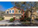 Charming two-story townhome featuring a two-car garage, beautifully landscaped yard, and colorful exterior at 5252 Hidden Cypress Ln, Oviedo, FL 32765