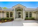 Welcoming front entrance featuring an arched entryway, large windows, and a well-maintained yard showcasing curb appeal at 5337 Foxshire Ct, Orlando, FL 32819