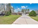 Charming single-story home featuring a long driveway and attached two-car garage at 5410 S Pine Hill Cir, Orlando, FL 32808