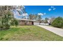 Charming single-story home featuring a long driveway and attached two-car garage at 5410 S Pine Hill Cir, Orlando, FL 32808