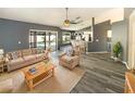 Bright, stylish living room with hardwood floors, neutral colors and sliding door access to outdoor pool at 8603 Primrose Dr, Kissimmee, FL 34747