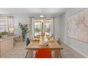 Bright dining room with a dining table set for eight, tile flooring, and views of the pool area at 9023 Shadow Mountain St, Davenport, FL 33896
