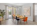 Bright dining room with a dining table set for eight, tile flooring, and glass doors to the pool area at 9023 Shadow Mountain St, Davenport, FL 33896