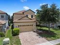 Attractive two story home with a tile roof, brick driveway and attached two car garage at 9023 Shadow Mountain St, Davenport, FL 33896