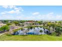 Aerial view of a serene pond with a fountain, surrounded by lush greenery and trees at 111 E Monument Ave # 705, Kissimmee, FL 34741
