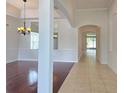Bright living room featuring hardwood floors, a decorative chandelier, and archway to an adjacent tiled room at 13413 Zori Ln, Windermere, FL 34786