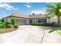 Charming single-story home with a well-maintained lawn, circular driveway, and mature tropical landscaping at 1489 Magellan Cir # 603, Orlando, FL 32818