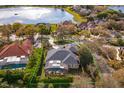 Aerial view of property showcasing landscaping, a screen-enclosed lanai, and a glimpse of the lake at 1704 Kersley Cir, Lake Mary, FL 32746