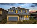 Charming two-story home featuring a covered entry, attached garage, and manicured lawn at sunset at 1735 Pine Ridge Dr, Davenport, FL 33896