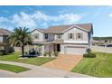 Charming two-story home showcases a brick driveway, well-manicured lawn, and appealing landscaping at 1880 Bonser Rd, Minneola, FL 34715
