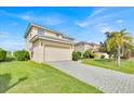 Two-story home with a paved driveway, a two-car garage, and manicured green lawn at 210 Vista Loop, Davenport, FL 33897