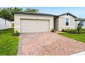A front exterior view showing the garage and the brick driveway at 2310 White Tail St, Davenport, FL 33837