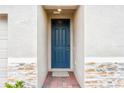 A blue painted front door with brickwork surrounding it at 2310 White Tail St, Davenport, FL 33837